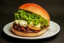 Burger mit Rindfleisch und Käse, Barbecue-Sauce, karamellisierte Zwiebeln, Salatblätter
